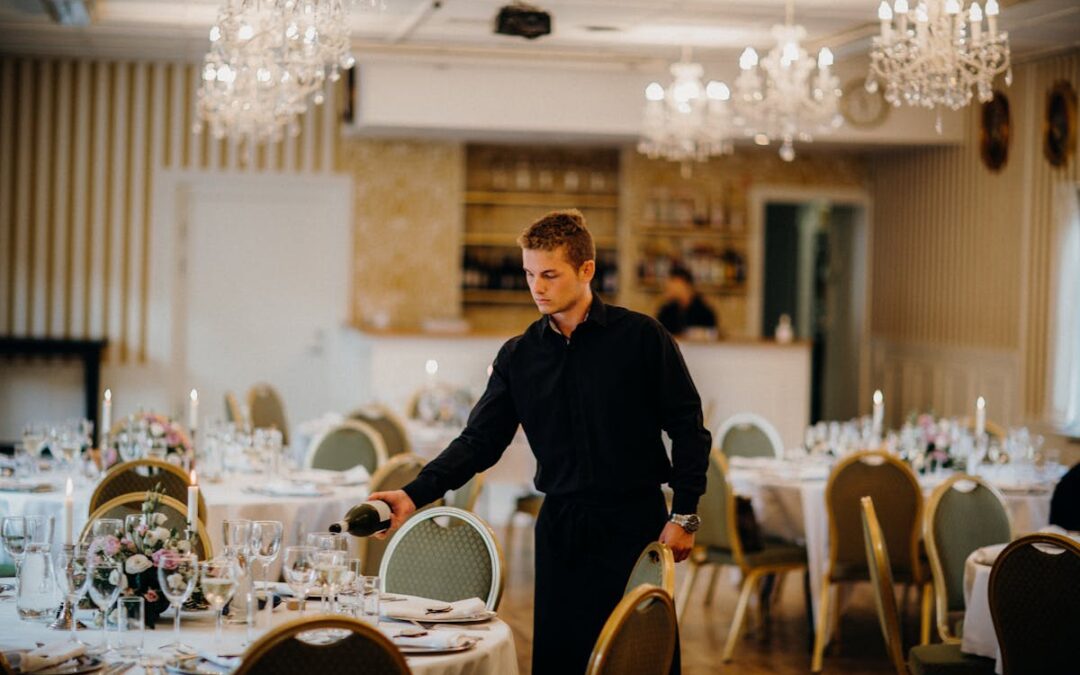 a man bringing water to a wedding table while catering